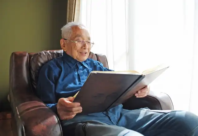 本を読みながら脳活を行うシニア男性